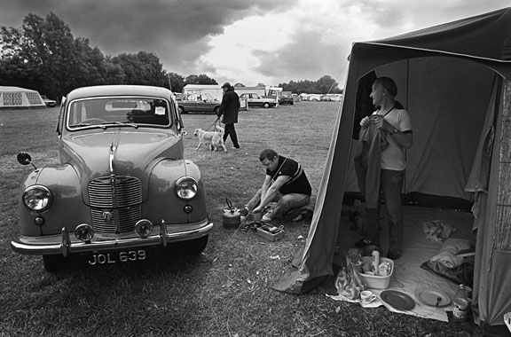black and white image of campers on a campsite. Good composition in this case lead the eye along leading lines