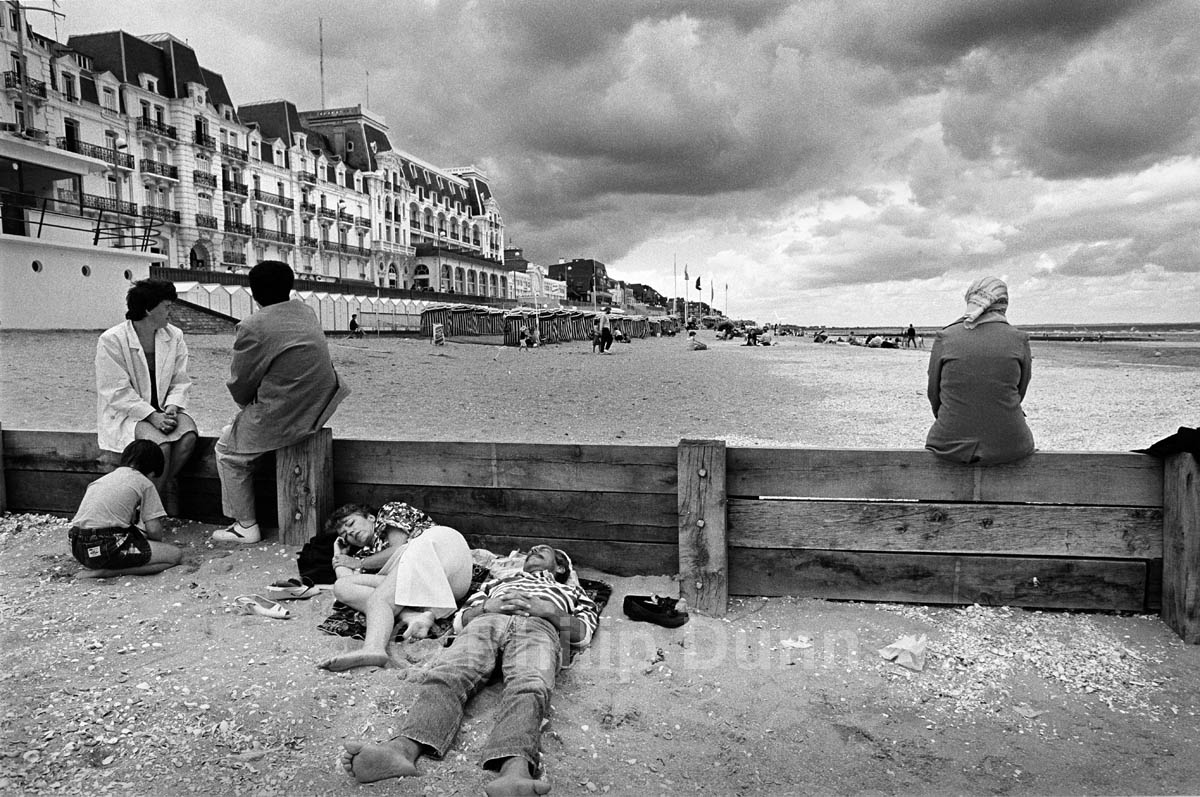 Street photograph. Family group on beach in Normandy