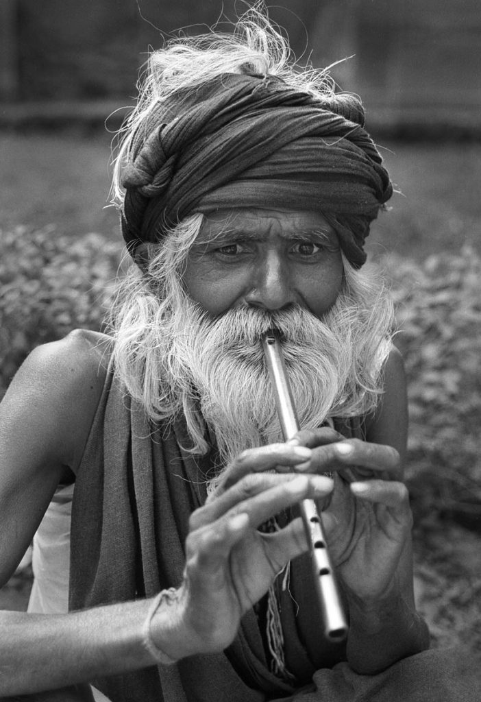 monochrome portrait of Indian man with tin whistle