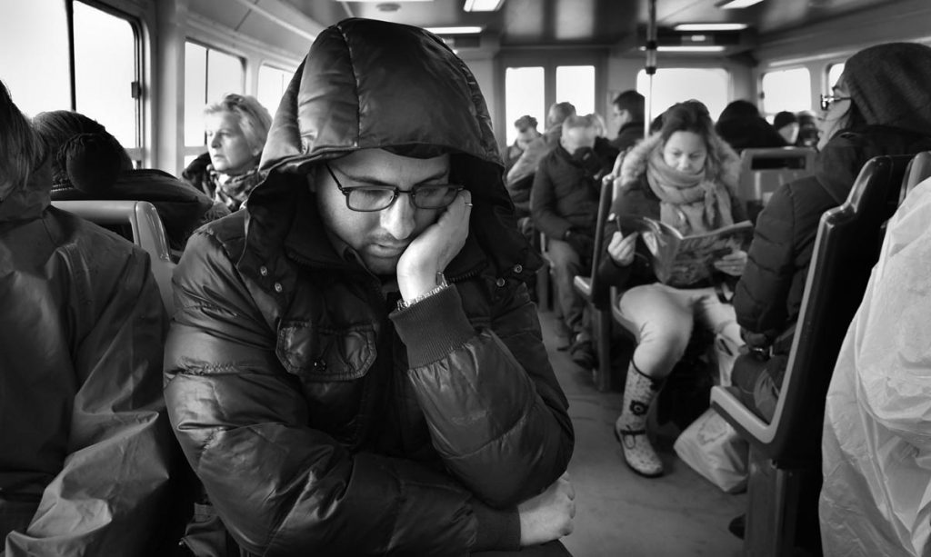 Passengers on Vaporetto, Venice. A man, heavily wrapped against the cold, snoozes in his seat