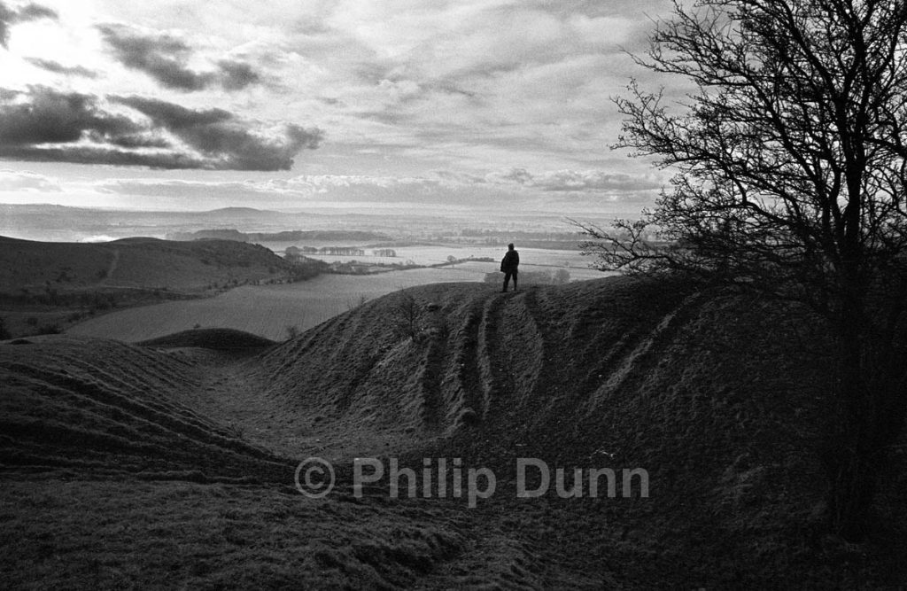 Wide angle lens shot of lone man on Wiltshire Downs at dawn