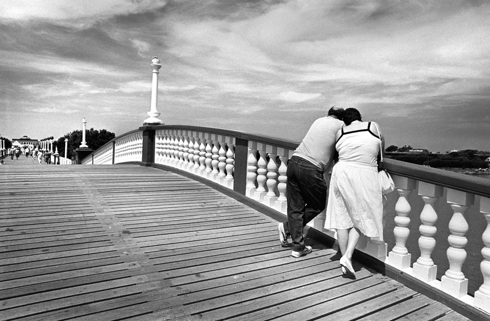 couple stand on the bridge in Marine park, Southport. UK